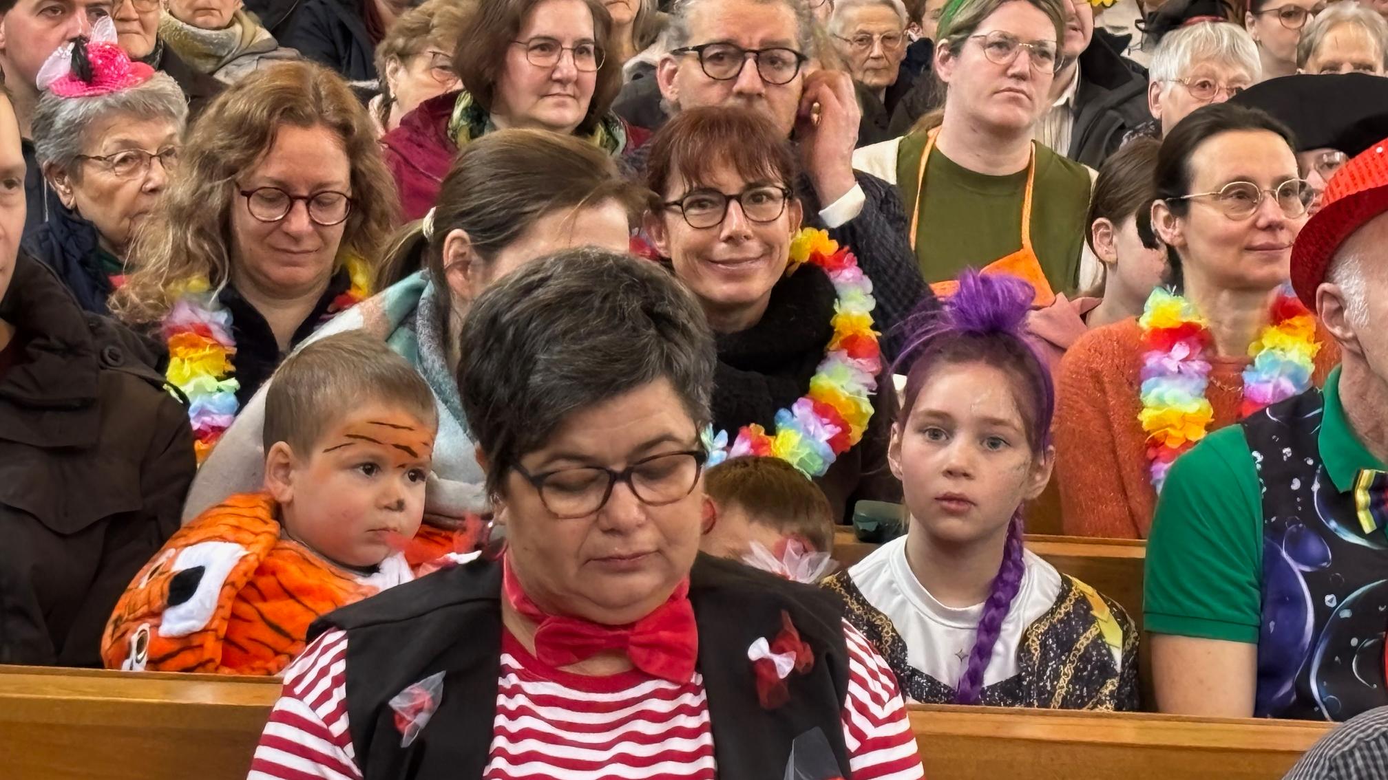 voll besetzt und bunt kostümiert feiert viele Gläubige beider Konfessionen den ökumenischen Karnevalsgottesdienst in Biebern mit