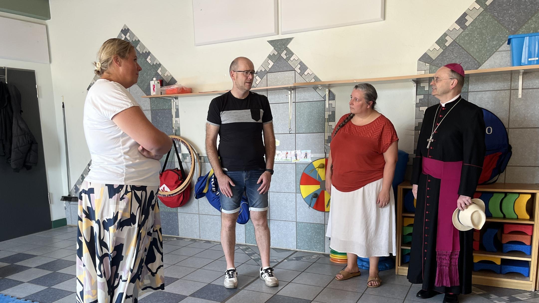Weihbischof Brahm schaut sich gemeinsam mit (v. links) Erzieherin Stefanie Dix, Standortleiter Stefan Wendling und Pastoralreferentin Lisa Lorsbach den Toberaum an.