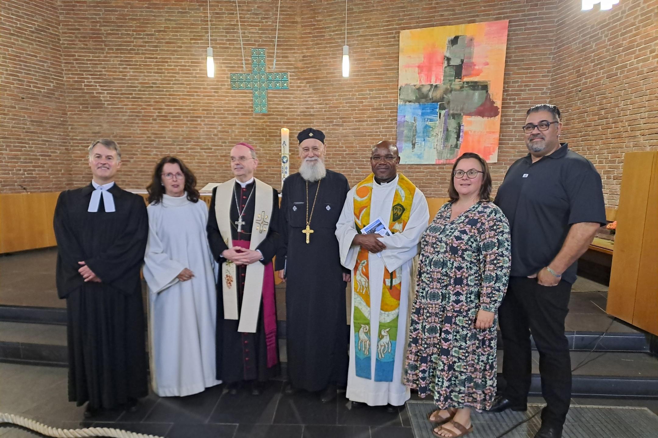 Superintendent Markus Risch vom evangelischen Kirchenkreis Simmern-Trarbach, Pastoralreferentin Anna Werle (Pastoraler Raum Simmern), der Trierer Weihbischof Robert Brahm, Vater Danyal Riad von der koptisch-orthodoxen Kirchengemeinde St. Nikolaus Kirchberg, Pater Dr. McDonald Kelechi (Kaycee) Nwandu vom Pastoralen Raum Simmern sowie Susan und Dave Sindhu von der Christuskirchengemeinde  (v.li.n.re.)